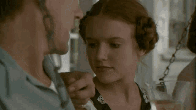 a man and a woman are touching each other 's faces in a room .