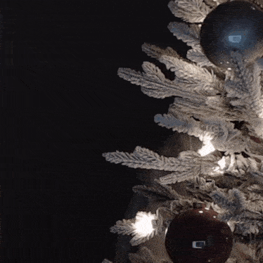 a close up of a christmas tree with decorations and lights