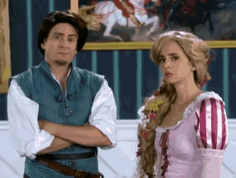 a man dressed as tangled and a woman dressed as rapunzel stand next to each other with their arms crossed