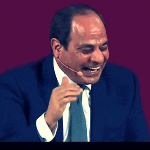 a man in a suit and tie is laughing while wearing a headset