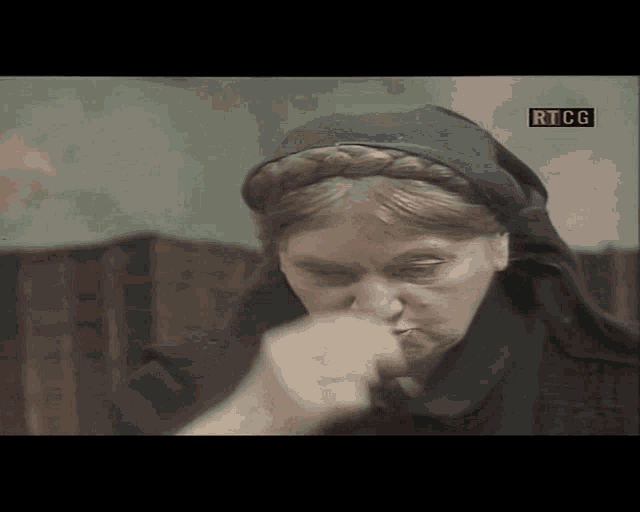 a woman with a scarf around her head and a rtcg logo in the corner