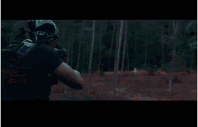 a man wearing a bandana and gloves is holding a camera .