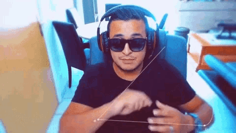 a man wearing headphones and sunglasses is making a hand gesture