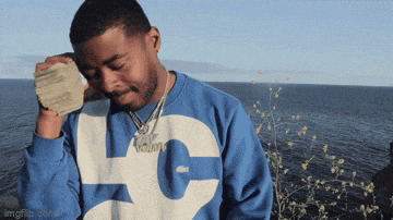 a man wearing a blue and white sweatshirt with the letter l on it