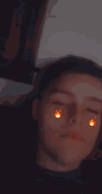 a close up of a person 's face with flames on his eyes