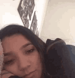 a woman is sitting on a couch with a stuffed animal in her lap .