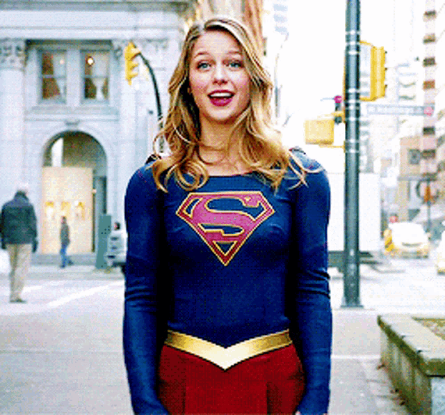 a woman is wearing a superman costume and smiling