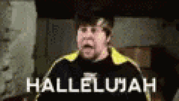 a man in a black and yellow jacket is standing in front of a wall and saying hallelujah .