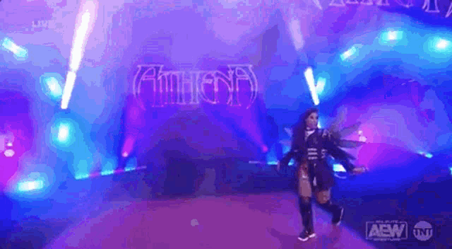 a woman is standing on a stage in front of a sign that says athena .