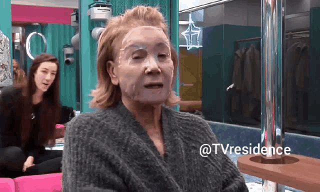 a woman with a mask on her face is sitting on a couch with the words @tvresidence below her