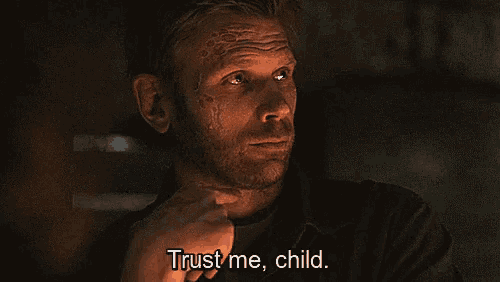 a man with a beard says " trust me child " in a dark room