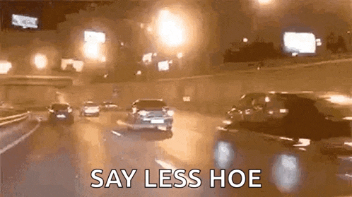 a car is driving down a highway at night with the words `` say less hoe '' written on the bottom .