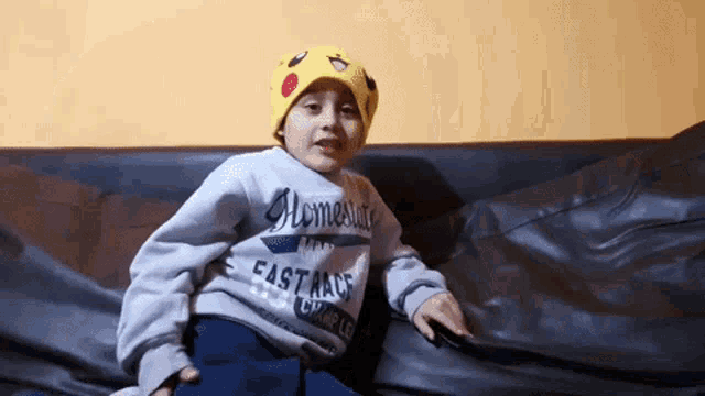 a little boy wearing a pikachu hat and a sweatshirt that says homestyle