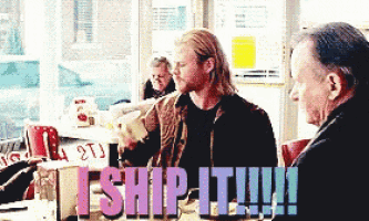 two men are sitting at a table with the words i ship it