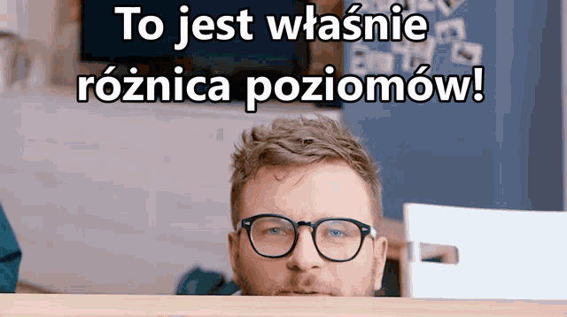 a man wearing glasses is peeking over a desk with the words to jest właśnie roznica poziomow