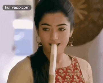 a woman is eating a banana with her tongue out .