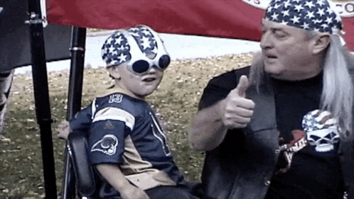 a man giving a thumbs up next to a child wearing a jersey that says rams on it