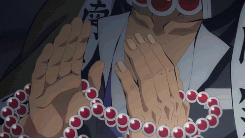 a close up of a person 's hands with red beads