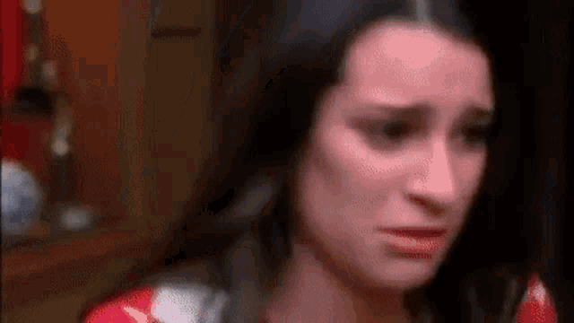a close up of a woman 's face with a tear running down her cheek .