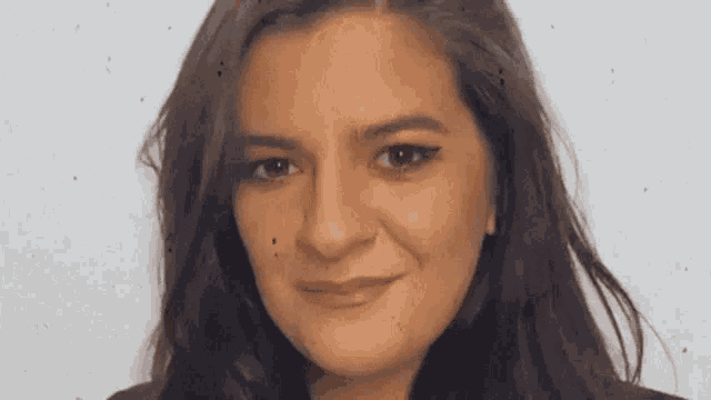 a close up of a woman 's face with a slight smile on her face .