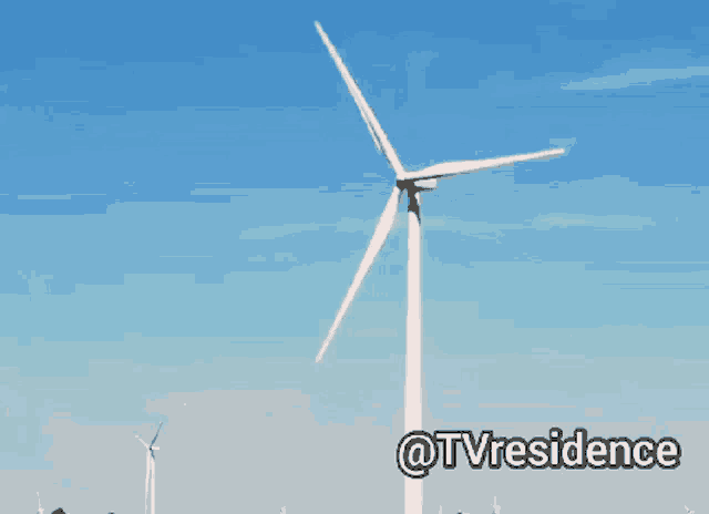 a wind turbine with a blue sky behind it and the words @tvresidence below it