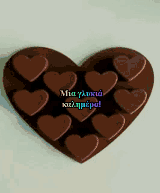 a heart made of chocolate hearts with a message in a foreign language on it