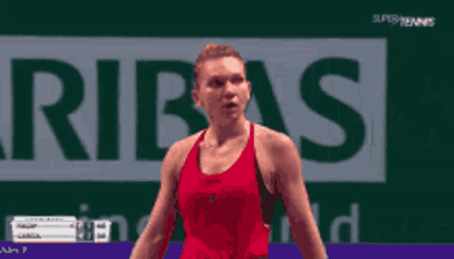 a woman in a red tank top is standing in front of an arifas logo