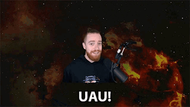 a man with a beard stands in front of a microphone with the words uau on his face