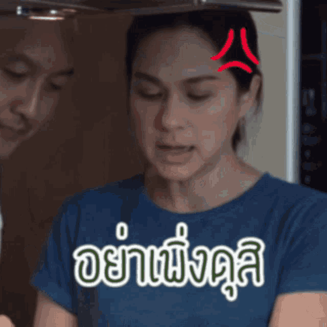 a woman wearing a blue shirt has a red angry face on her forehead