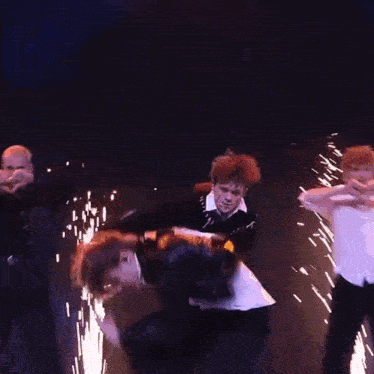 a group of dancers are performing on a stage with sparks flying