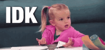 a little girl is sitting at a table with a piece of paper in her hand and the word idk behind her .