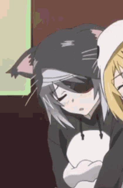 a girl in a cat costume is sleeping next to another girl in a hoodie .
