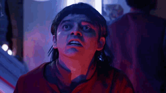 a close up of a person 's face in a red shirt
