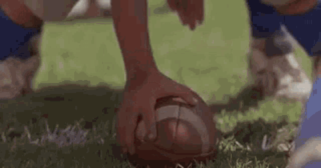 a close up of a football being kicked by a player on a field .