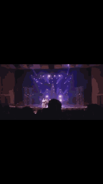a group of women are dancing on a stage in a row .