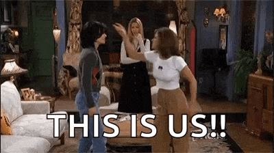 a group of women are standing in a living room and giving each other high fives .