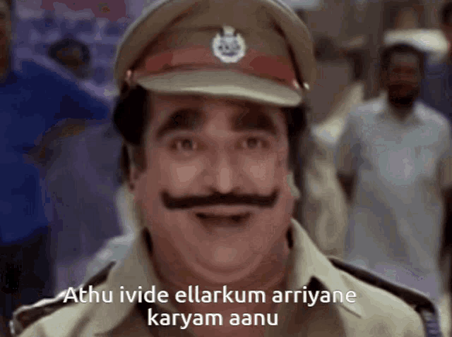 a man with a mustache is wearing a hat and says " athu ivide ellarkum ariyane karyam aanu "