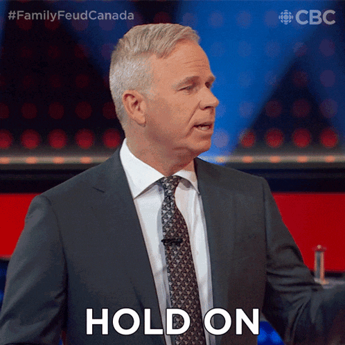 a man in a suit and tie says hold on in front of a cbs logo