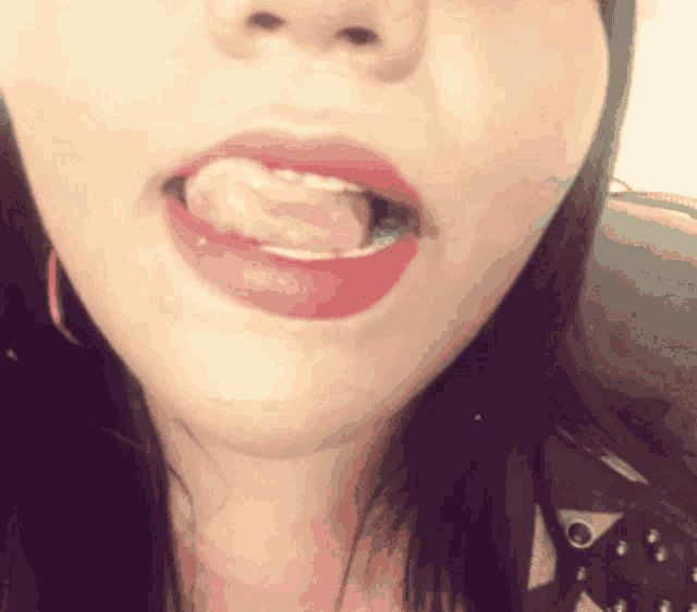 a close up of a woman 's face with her tongue out