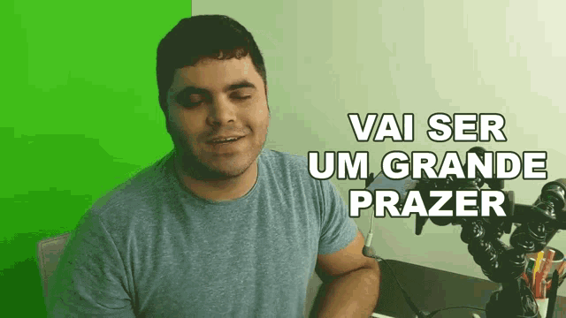 a man sitting in front of a green screen with the words vai ser um grande prazer