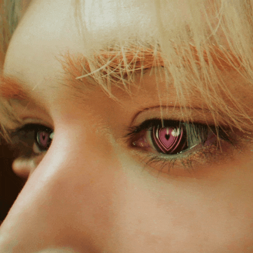 a close up of a person 's eye with a pink heart on it
