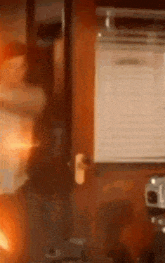 a blurred image of a room with a fire coming out of a door