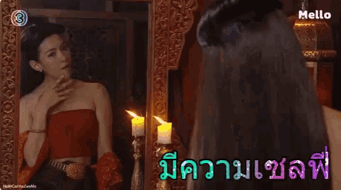 a woman in a red top is looking at herself in a mirror with the number 3 on the bottom