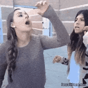 two women are standing next to each other and one of them is making a funny face ..