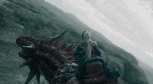 a person is riding on the back of a dragon on a mountain .