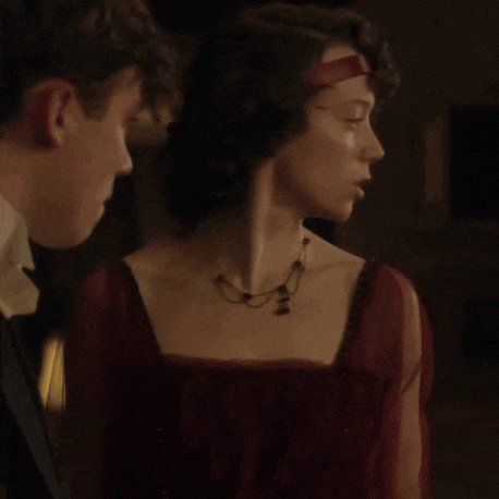 a woman in a red dress stands next to a man in a suit