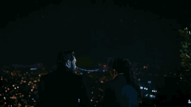 a man and a woman are looking at the night sky