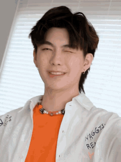 a young man wearing an orange shirt and a white shirt that says avaggis real