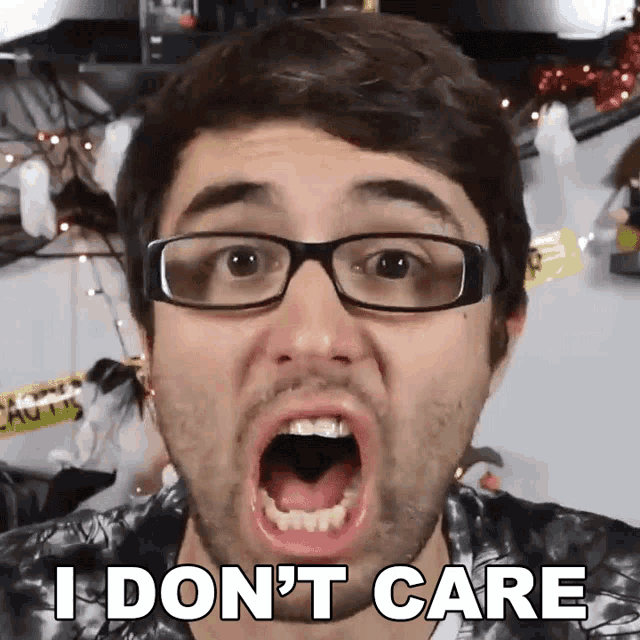 a man with glasses is making a funny face with the words " i don 't care " behind him