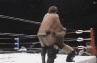 two men are wrestling in a ring with a blurred background